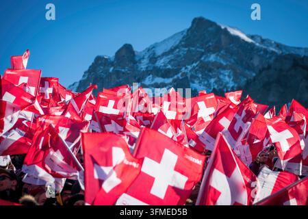 Adelboden, Schweiz - 7. Januar 2023: Ein Meer von Flaggen, die die Schweizer Unterstützung durch Tausende von Fans beim Alpinen Skiweltcup gegen den schneebedeckten Berg zeigen Stockfoto