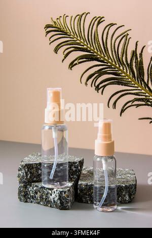 Eine Reihe von Kosmetika auf einem beigen Hintergrund auf einem Steinpodest mit einem Blatt getrockneter Farnblüte. Gesunde Kosmetologie, das Konzept der Spa-Behandlung Stockfoto