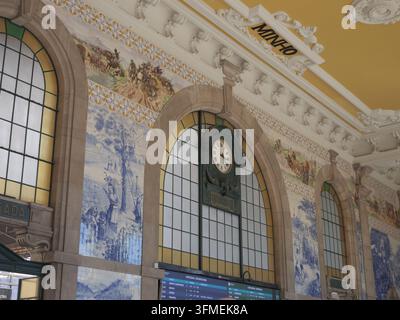 Ansicht der kunstvollen blauen und weißen Azulejo-Fliesenmosaike und der historischen Uhr im Bahnhof Sao Bento in Porto, Distrikt Porto, Portugal Stockfoto