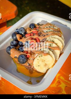 Papaya-Bowl-Frühstück serviert in einer halben Papaya mit glutenfreier Granola, Bananen, Blaubeeren, Kokosflocken, Goji-Beeren, Hanfsamen, Chiasamen, ca Stockfoto