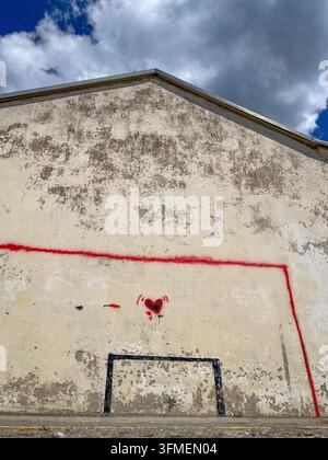 Niedrige Perspektive von bemalten Fußballtoren und rotem Herz-Graffiti an einem Haus in Italien Stockfoto