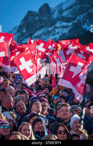 Adelboden, Schweiz - 7. Januar 2023: Ein Meer von Flaggen, die die Schweizer Unterstützung durch Tausende von Fans beim Alpinen Skiweltcup gegen den schneebedeckten Berg zeigen Stockfoto