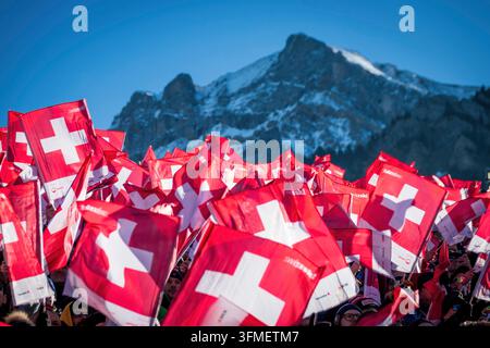 Adelboden, Schweiz - 7. Januar 2023: Ein Meer von Flaggen, die die Schweizer Unterstützung durch Tausende von Fans beim Alpinen Skiweltcup gegen den schneebedeckten Berg zeigen Stockfoto