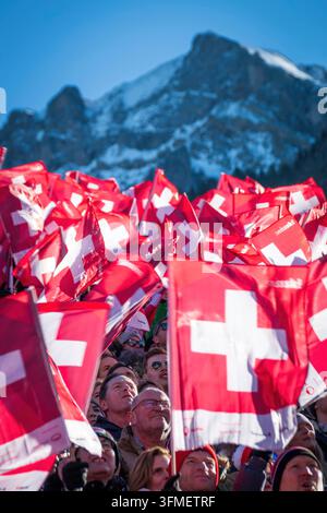 Adelboden, Schweiz - 7. Januar 2023: Ein Meer von Flaggen, die die Schweizer Unterstützung durch Tausende von Fans beim Alpinen Skiweltcup gegen den schneebedeckten Berg zeigen Stockfoto