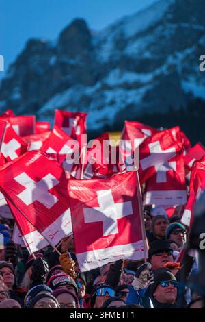Adelboden, Schweiz - 7. Januar 2023: Ein Meer von Flaggen, die die Schweizer Unterstützung durch Tausende von Fans beim Alpinen Skiweltcup gegen den schneebedeckten Berg zeigen Stockfoto