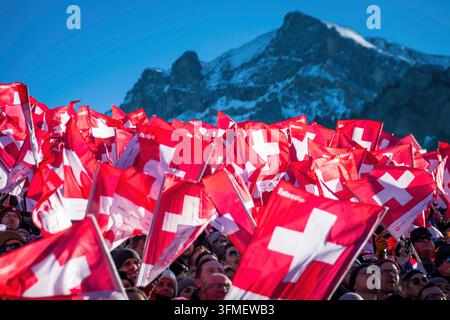 Adelboden, Schweiz - 7. Januar 2023: Ein Meer von Flaggen, die die Schweizer Unterstützung durch Tausende von Fans beim Alpinen Skiweltcup gegen den schneebedeckten Berg zeigen Stockfoto