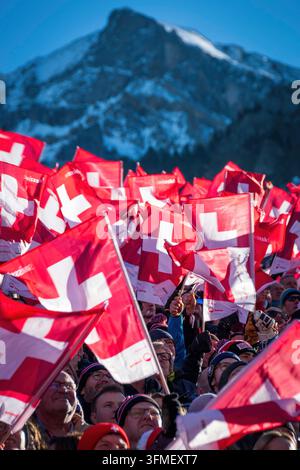 Adelboden, Schweiz - 7. Januar 2023: Ein Meer von Flaggen, die die Schweizer Unterstützung durch Tausende von Fans beim Alpinen Skiweltcup gegen den schneebedeckten Berg zeigen Stockfoto
