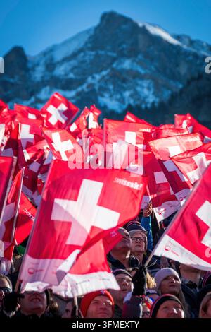 Adelboden, Schweiz - 7. Januar 2023: Ein Meer von Flaggen, die die Schweizer Unterstützung durch Tausende von Fans beim Alpinen Skiweltcup gegen den schneebedeckten Berg zeigen Stockfoto