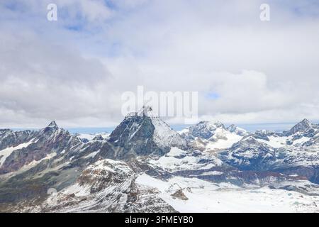 Majestätischer schneebedeckter Gipfel des ikonischen Matterhorns, umgeben von alpinen Gletschern und Wolken in der Schweiz Stockfoto