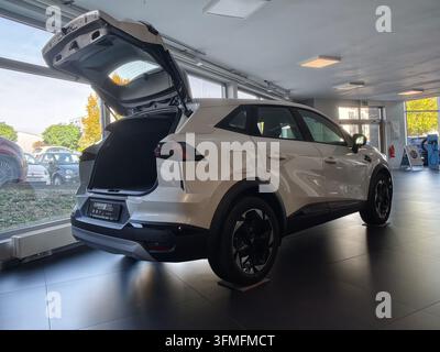 Pforzheim, Deutschland - 28. September, Deutschland Hecksicht von weißem Crossover-SUV, der in einem hellen modernen Ausstellungsraum geparkt ist, Heckklappe geöffnet, um e zu enthüllen Stockfoto