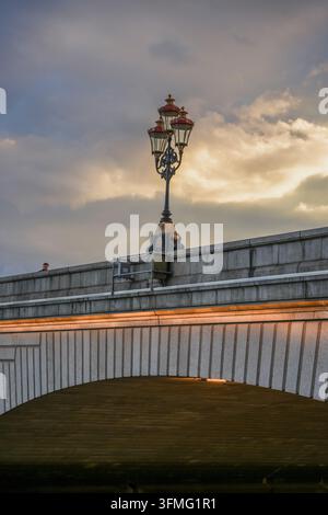 Verzierte historische Lampe und Steinbogen der Putney Bridge über der Themse. Stockfoto