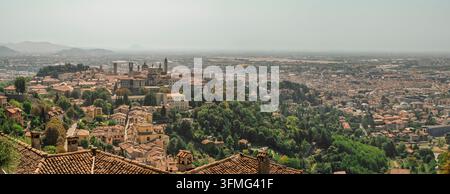 Panoramablick auf die Stadt von San Vigilio aus an einem heißen, schwülen Sommertag; im Hintergrund, in der Ebene, die Landebahn des internationalen Flughafens Orio al Serio Stockfoto