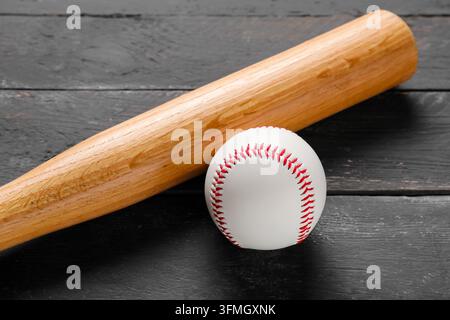 Baseball und Holzschläger, Sportwettbewerb und Trainingskonzept, professionelle Liga-Ausrüstung auf einem dunklen rustikalen Holz-Hintergrund Stockfoto