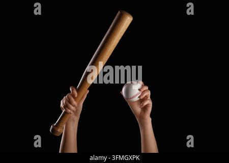 Baseballwettbewerb und Sporttraining, Hände halten einen Holzschläger und einen Ball vor schwarzem Hintergrund Stockfoto