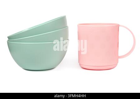Ein Satz Plastikutensilien. Teller und eine Tasse auf weißem Hintergrund. Modernes Plastikgeschirr auf weißem Hintergrund. Stockfoto