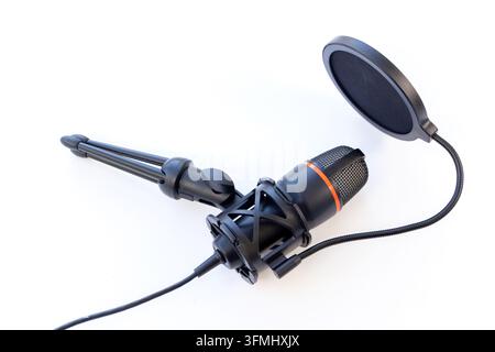 Schwarzes Studiomikrofon mit Ständer und Popfilter auf weißem Hintergrund Stockfoto