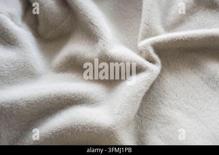 Weiche graue Woll-Decke im Nahaufnahme, die plüschigen Flor zeigt. Zarte Textur und sanfte Falten für Mode-Winter- oder Herbstkleidung. Evokiert Wärme, com Stockfoto