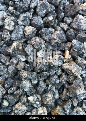 Haufen rauer Natursteine, die eine detaillierte mineralische Hintergrundtextur erzeugen Stockfoto