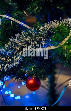 Festliche Weihnachtsdekoration, die an einem leuchtenden immergrünen Ast hängt Stockfoto