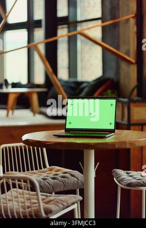 Laptop mit Chroma-Key-Grünhintergrund auf dem Tisch für App-Mockup Stockfoto