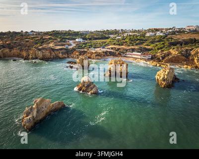 Luftbild des Strandes Praia dos Arrifes in der Algarve mit felsigen Klippen, Küstenfelsen vor der Küste und ruhigem Atlantikwasser. Stockfoto