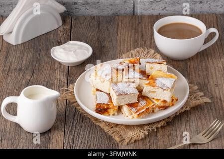 Leckeres Gebäck mit Kaffee und Sahne auf Holztablett Stockfoto