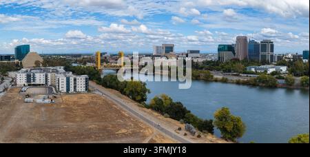Luftbild des Sacramento River, der an der ikonischen gelben Tower Bridge vorbei in Richtung der Bürohochhäuser der Innenstadt von Sacramento, Kalifornien, unter s Stockfoto