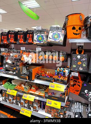 Supermarkt-Saisonregal für Halloween mit Kürbisdekorationen, Masken und orange-schwarzer Ware. Stockfoto