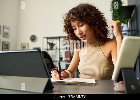 Junge Designerin macht Notizen im Kreativstudio Stockfoto