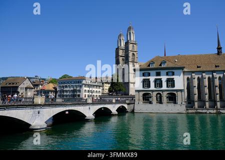Die historische Grossmünster-Kirche, Wasserkirche und Münsterbrücke, die den Limmat in Zürich, Schweiz, unter einem klaren blauen Himmel überspannt. Stockfoto