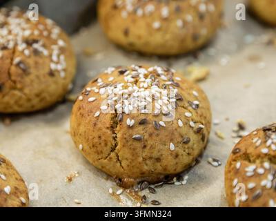 Frisch gebackene Brotscheiben mit Samen, auf Pergamentpapier angeordnet Stockfoto