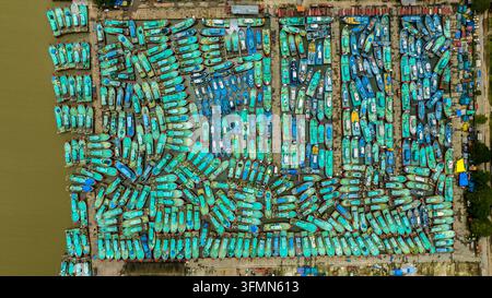 Luftaufnahme des Fischereihafens Malpe, der mit zahlreichen bunten Fischerbooten gefüllt ist, die in Reihen im Wasser angelegt haben, und die lebendige maritime Aktivität zeigt Stockfoto