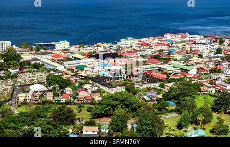 Panoramische Luftaufnahme von Roseau, der Hauptstadt von Dominica, mit farbenfrohen Gebäuden, üppiger Vegetation und dem tiefblauen Karibischen Meer. Stockfoto