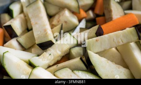 Verschiedene gehackte Zucchini, Auberginen und Karotten arrangiert in einer farbenfrohen Nahaufnahme von frischem Gemüsemix zum Kochen Stockfoto