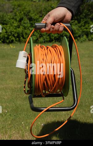 Langes orangefarbenes elektrisches Verlängerungskabel Stockfoto