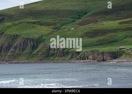Ein malerischer Blick auf ein steiles grünes Grashalbinsel, das in einer felsigen Klippe endet, die an der rauen Küste der Insel Hoy ins Meer abfällt Stockfoto
