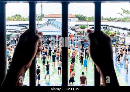 eine Silhouette einer Person in einer Zelle mit vertikalen Eisenstäben, häufig verwendet als Stockillustration für rechtliche Inhaftierung oder Gefangenenthemen Stockfoto