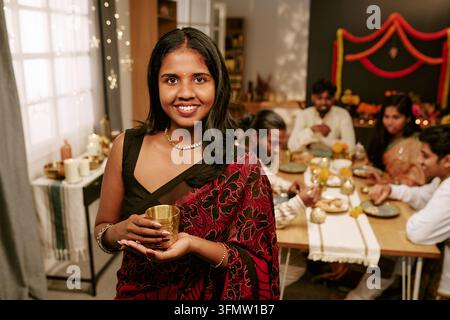Porträt einer lächelnden indischen Frau, die ein festliches Familienessen feiert Stockfoto