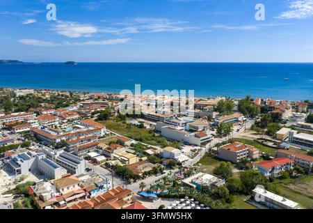 Luftbild zeigt das Küstenresort Zakynthos mit Hotels, Häusern, Straßen, Schwimmbädern, dem blauen Ionischen Meer und Booten vor der Küste über die Mittelmeerinsel hinweg Stockfoto