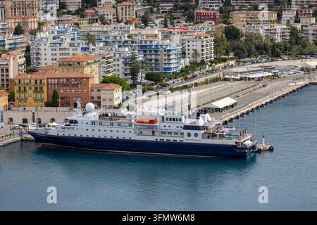 Luftaufnahme eines Kreuzfahrtschiffes, das im Hafen von Nizza angelegt hat, mit städtischen Gebäuden und Küsteninfrastruktur in Nizza, Provence-Alpes-Côte d'Azur, Frankreich. Stockfoto