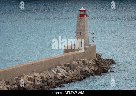 Luftaufnahme des historischen Leuchtturms im Hafen von Nizza, der einen Steinturm mit einer roten Laterne zeigt, der am Ende einer Mole in Nizza liegt, P Stockfoto