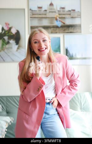 Frau in einem rosa Blazer hält eine fesselnde Präsentation, veranschaulicht öffentliches Reden, Expertise, Motivation und professionelles Selbstvertrauen. Stockfoto