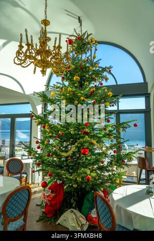 Großer geschmückter Weihnachtsbaum in einem eleganten Seerestaurant Stockfoto