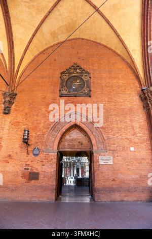 Bologna, Italien, 4. August 2026. Eine Weitwinkelaufnahme des historischen Ziegereingangs des Palazzo della Mercanzia in Bologna, der sein großes gotisches Tor zeigt Stockfoto