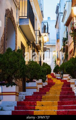 Calle Puchalt, eine beliebte Fußgängerzone im historischen Zentrum, mit Stufen, die in den Farben der spanischen Flagge bemalt sind. Calpe, Alicante, Spanien. Stockfoto