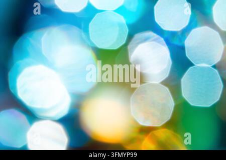 Abstrakter blauer Bokeh-Hintergrund mit weichen, farbenfrohen verschwommenen Lichtkreisen in Zyan, Grün, Gelb und Weiß, die eine träumerische leuchtende Textur erzeugen Stockfoto