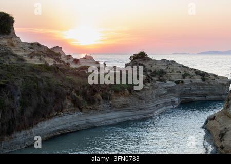 atemberaubender Sonnenuntergang über felsigen Küstenklippen und ruhigem Meer Stockfoto
