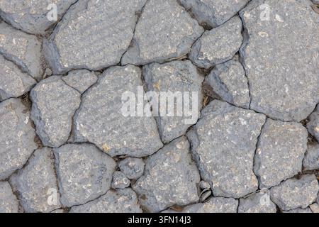 Rissiger grauer Steinpflasterboden – Raue Felsboden-Textur-Hintergrund Stockfoto