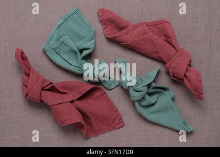 Farbige Leinenservietten auf Leinenstoff. Oberansicht, Flat Lay. Das Konzept von natürlichen Eco-Stoffen. Stockfoto