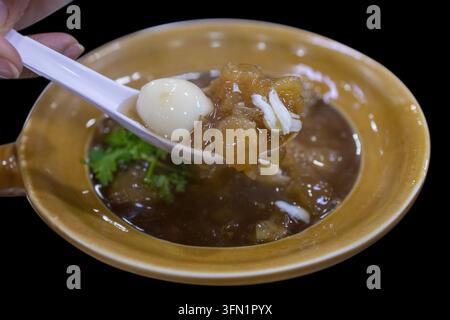 Nahaufnahme einer chinesischen gebratenen Fischmaw-Suppe, serviert in einem braunen Keramik-Tontopf mit Griff. Isoliert auf einem sauberen weißen Hintergrund, perfekt f Stockfoto